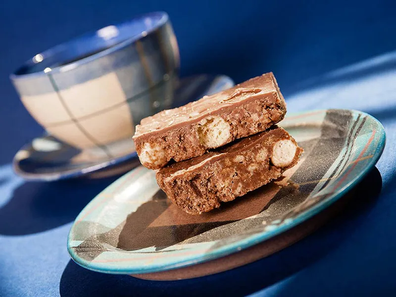 cake and coffee cup beautifully lit on blue background commercial and promotional photographer in Fife